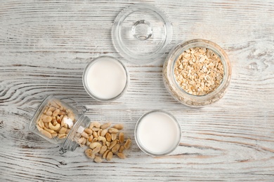 Composition with peanut and oat milk on wooden background