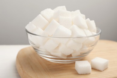 Bowl with sugar cubes on white table, closeup