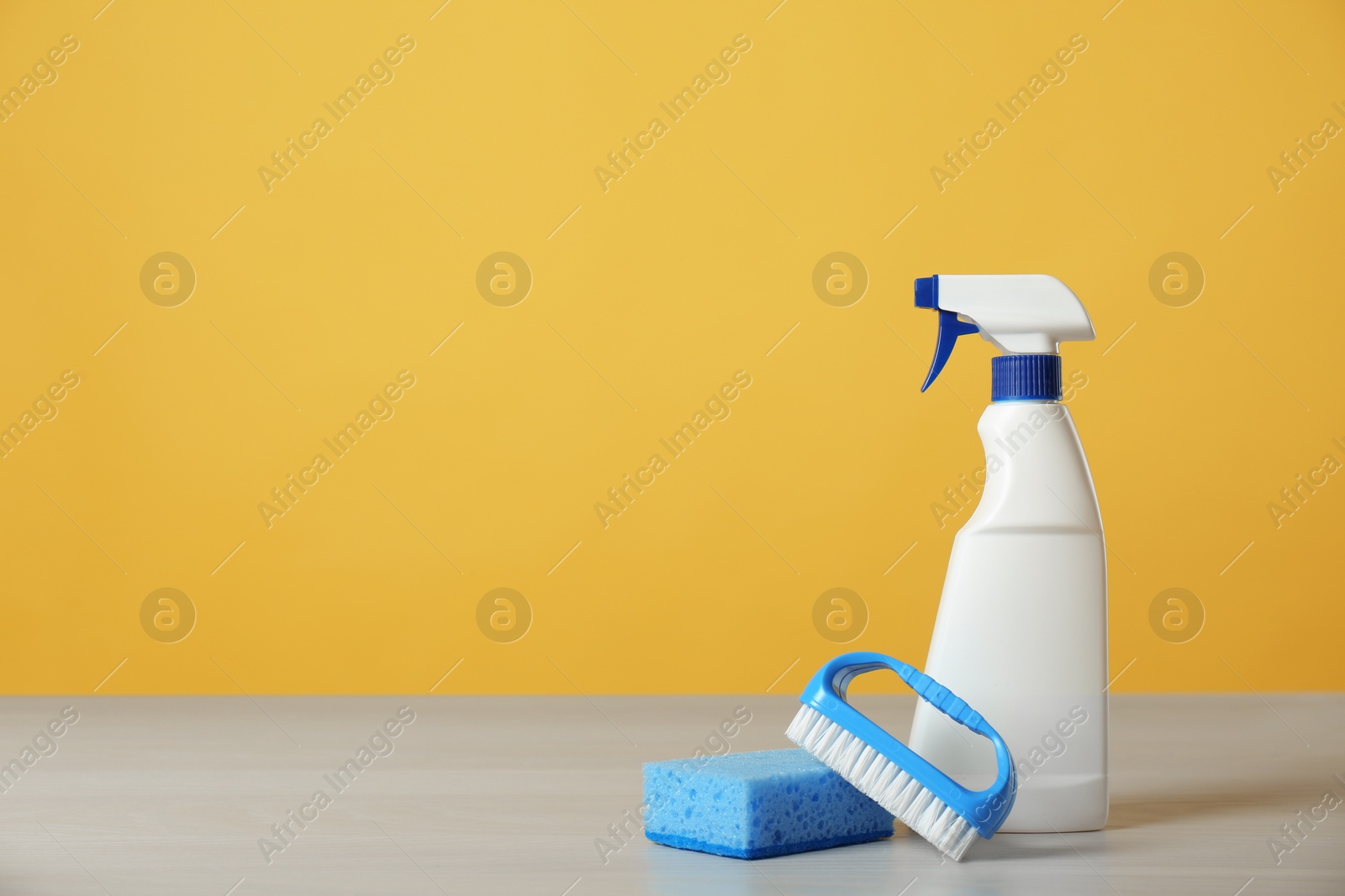 Photo of Bottle of cleaning product and supplies on light table. Space for text