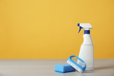 Photo of Bottle of cleaning product and supplies on light table. Space for text