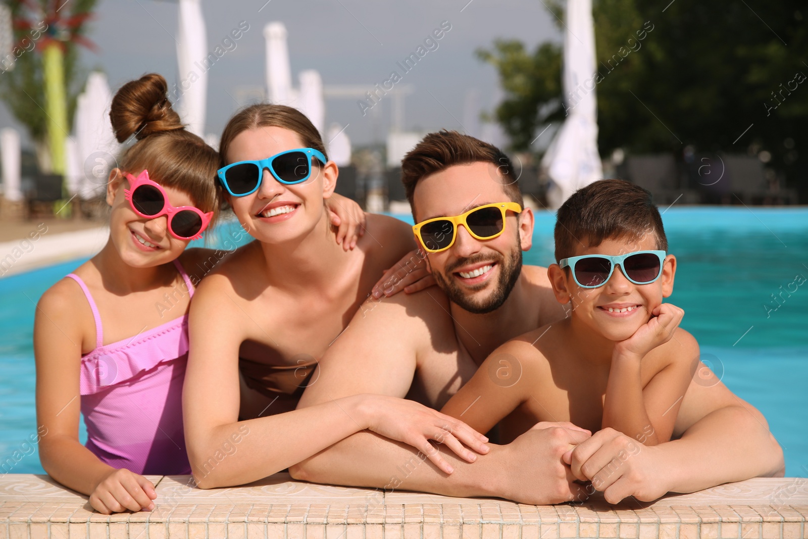 Photo of Happy family in swimming pool on sunny day