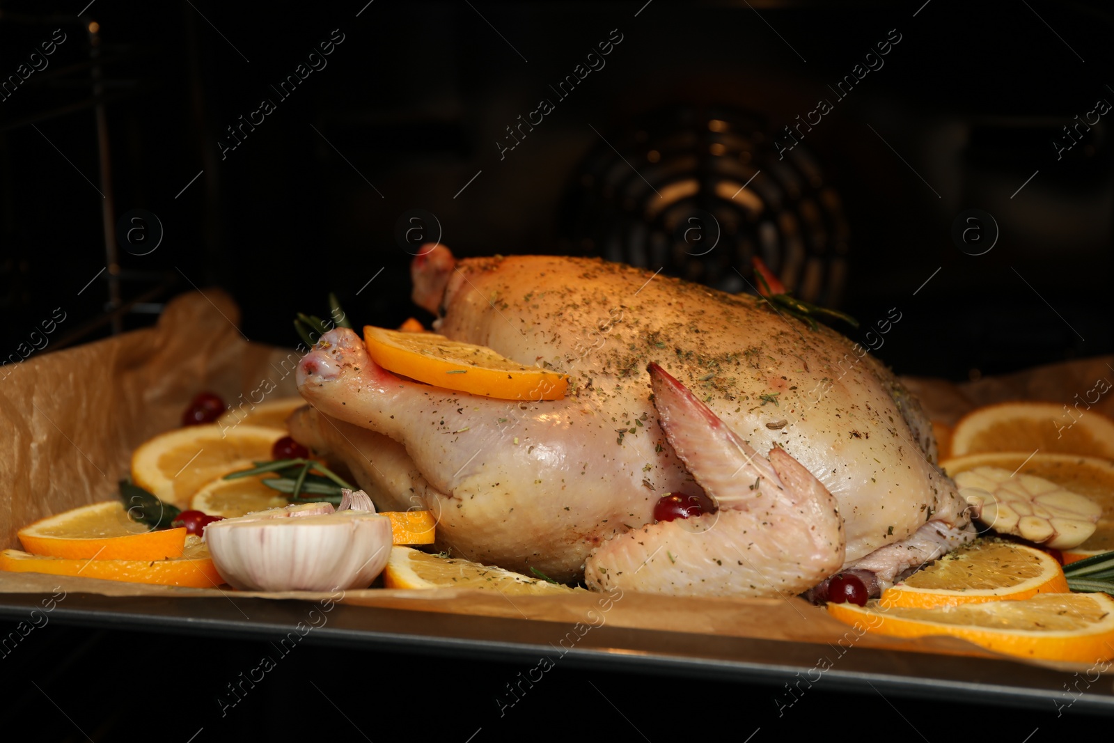 Photo of Chicken with orange slices baking in oven