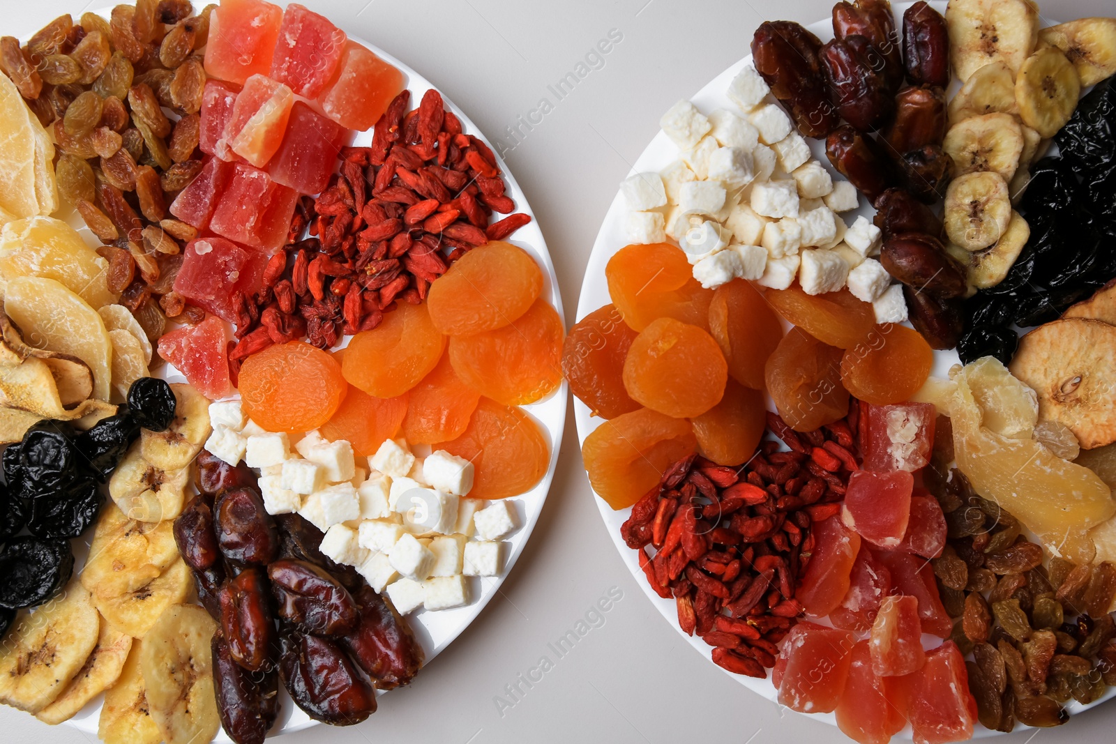 Photo of Plates with different dried fruits on white background, top view