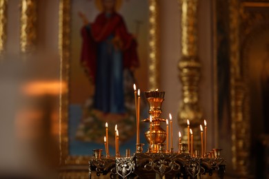 Photo of Beautiful stand with burning candles in church. Baptism ceremony