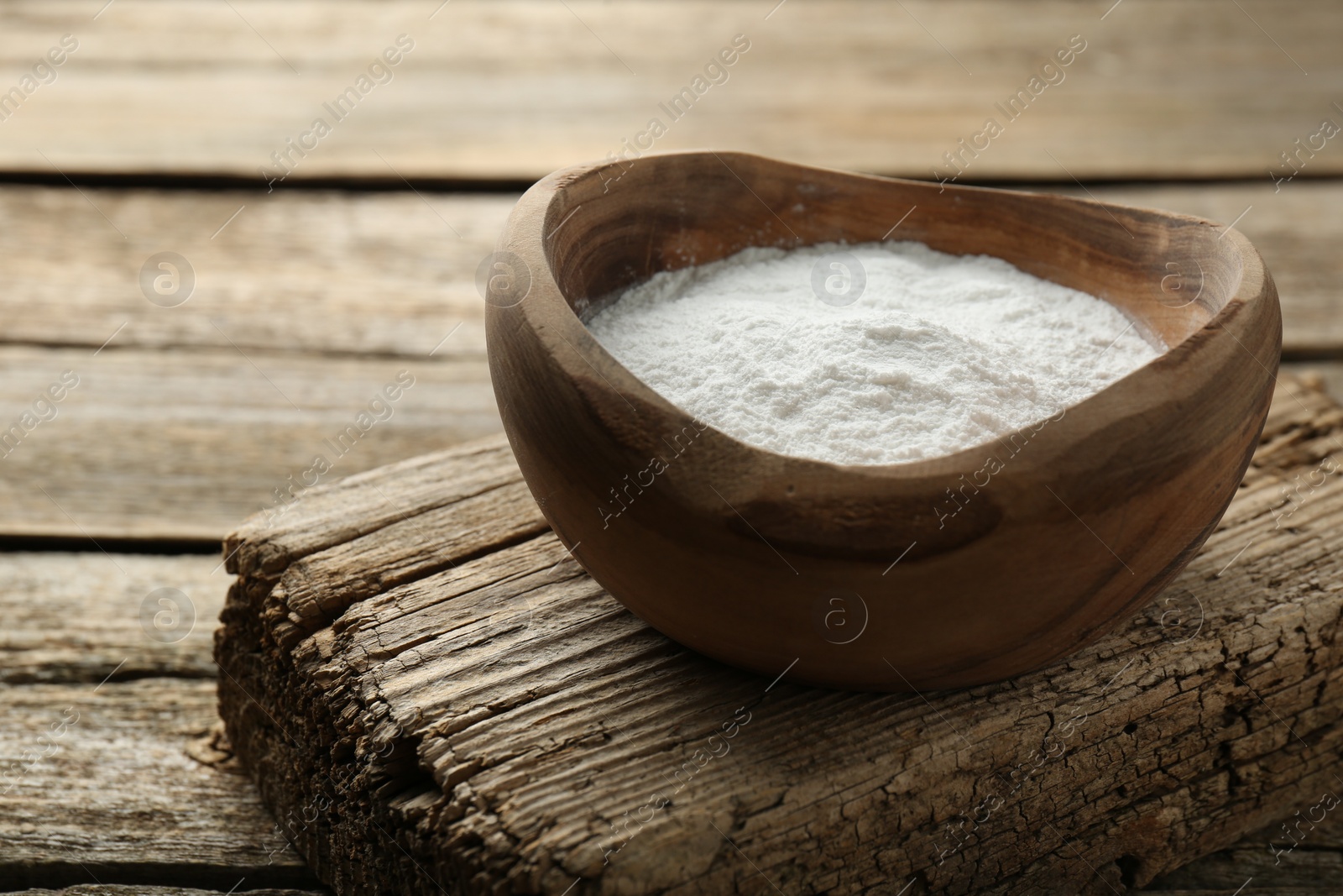 Photo of Baking powder in bowl on wooden table, space for text