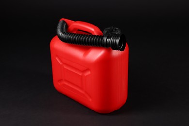 New red plastic canister on black background