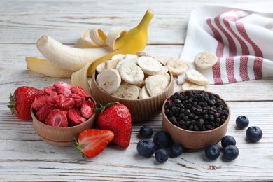 Photo of Different freeze dried and fresh fruits on white wooden table