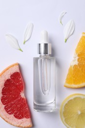 Bottle of cosmetic serum, flower petals and citrus fruit slices on white background, flat lay