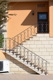 Photo of Beautiful stairs with metal railings of orange house outdoors
