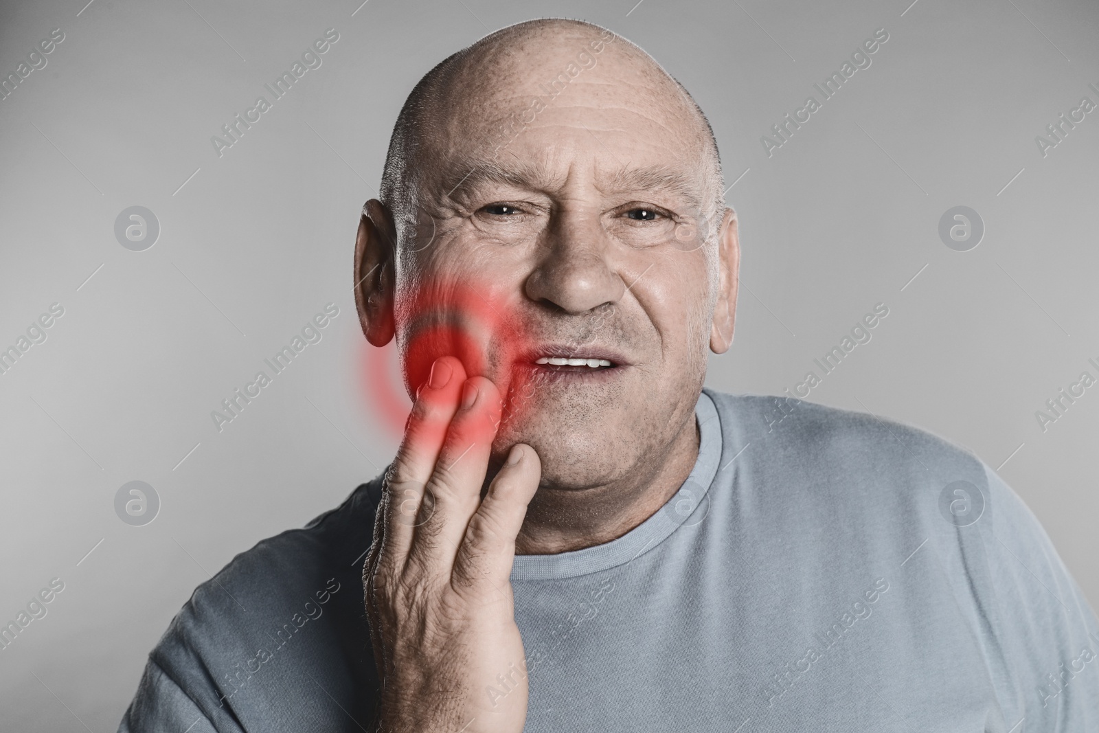 Image of Senior man suffering from toothache on grey background