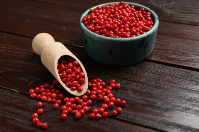 Aromatic spice. Red pepper in bowl and scoop on wooden table, closeup