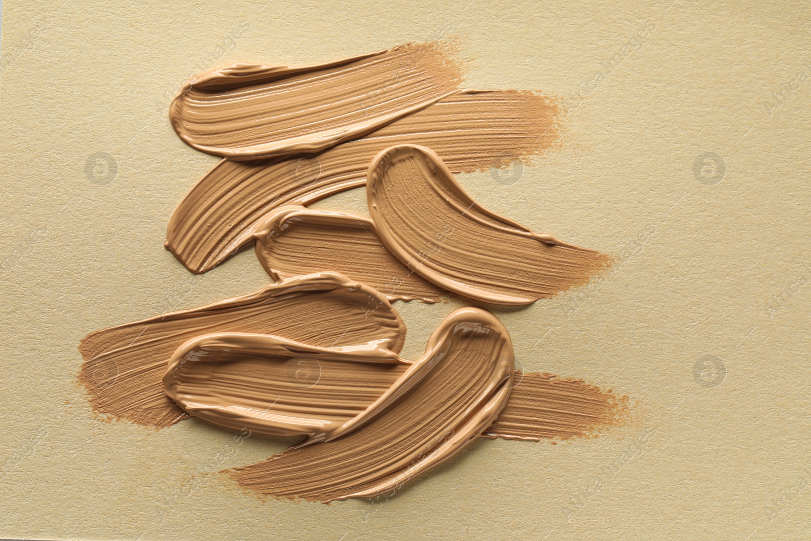 Photo of Sample of liquid skin foundation on beige background, top view