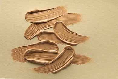 Photo of Sample of liquid skin foundation on beige background, top view