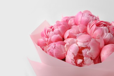 Bouquet of beautiful pink peonies near white wall, closeup