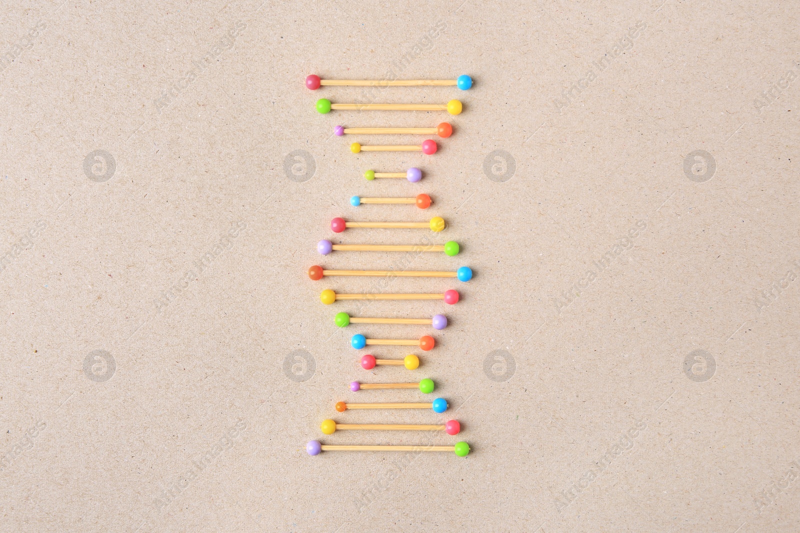 Photo of Model of DNA molecular chain on beige background, top view