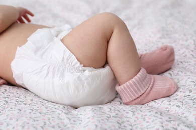 Little baby in diaper on bed, closeup