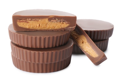 Cut and whole delicious peanut butter cups on white background