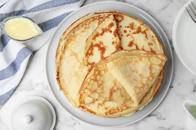 Photo of Flat lay composition with fresh thin pancakes on white marble table