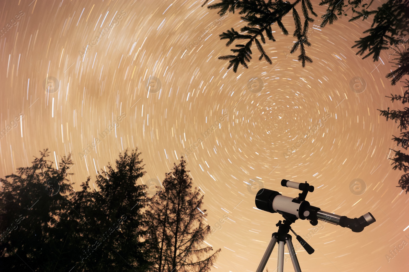 Photo of Modern telescope and beautiful sky outdoors, low angle view. Star trail