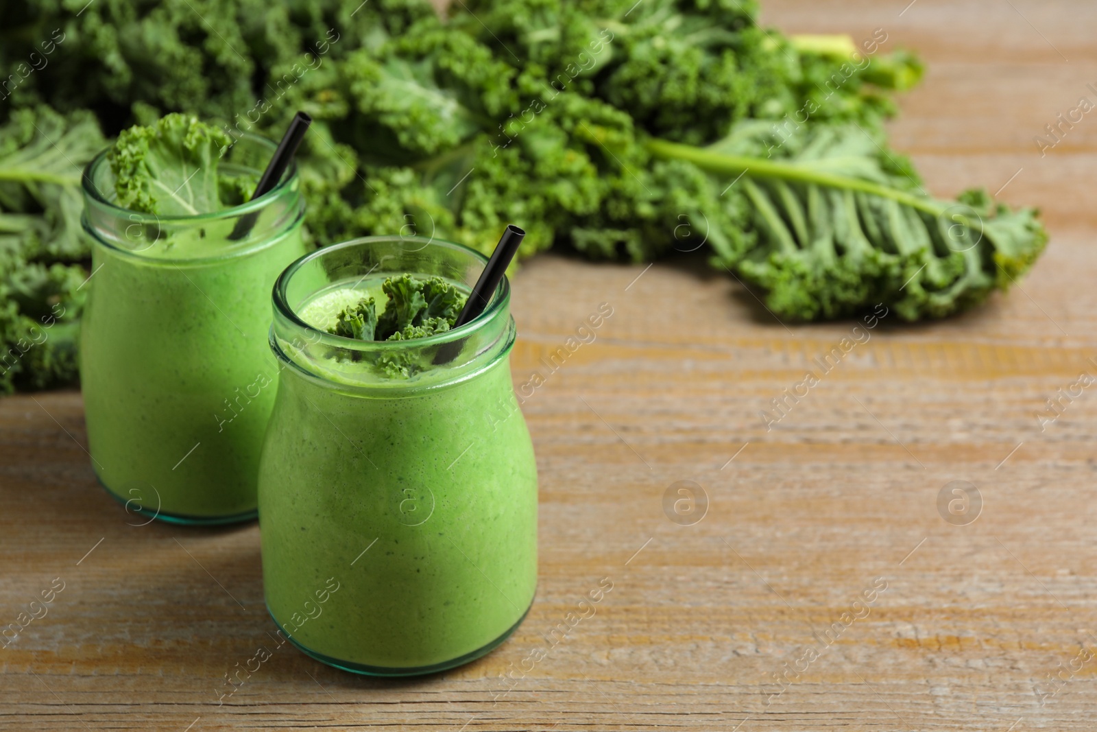 Photo of Tasty fresh kale smoothie on wooden table