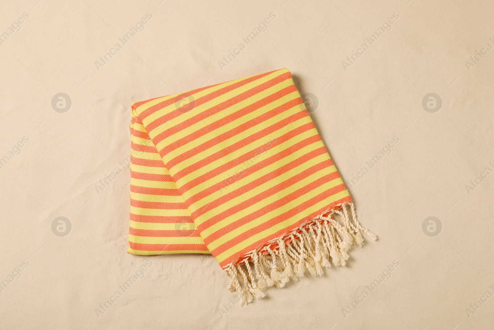 Photo of Striped beach towel on sand, top view