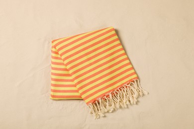 Striped beach towel on sand, top view