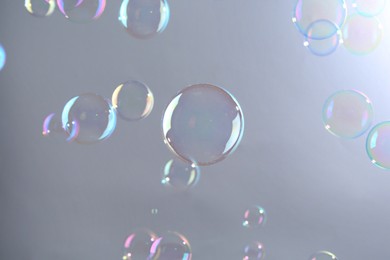 Photo of Beautiful transparent soap bubbles on gray background