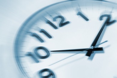Image of Fleeting time concept. Clock on light background, closeup. Motion effect