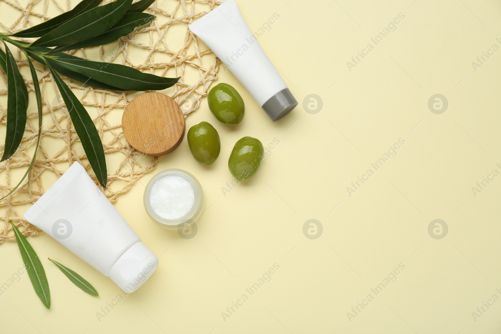 Photo of Cosmetic products with olive essential oil on beige background, flat lay. Space for text