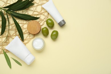 Photo of Cosmetic products with olive essential oil on beige background, flat lay. Space for text