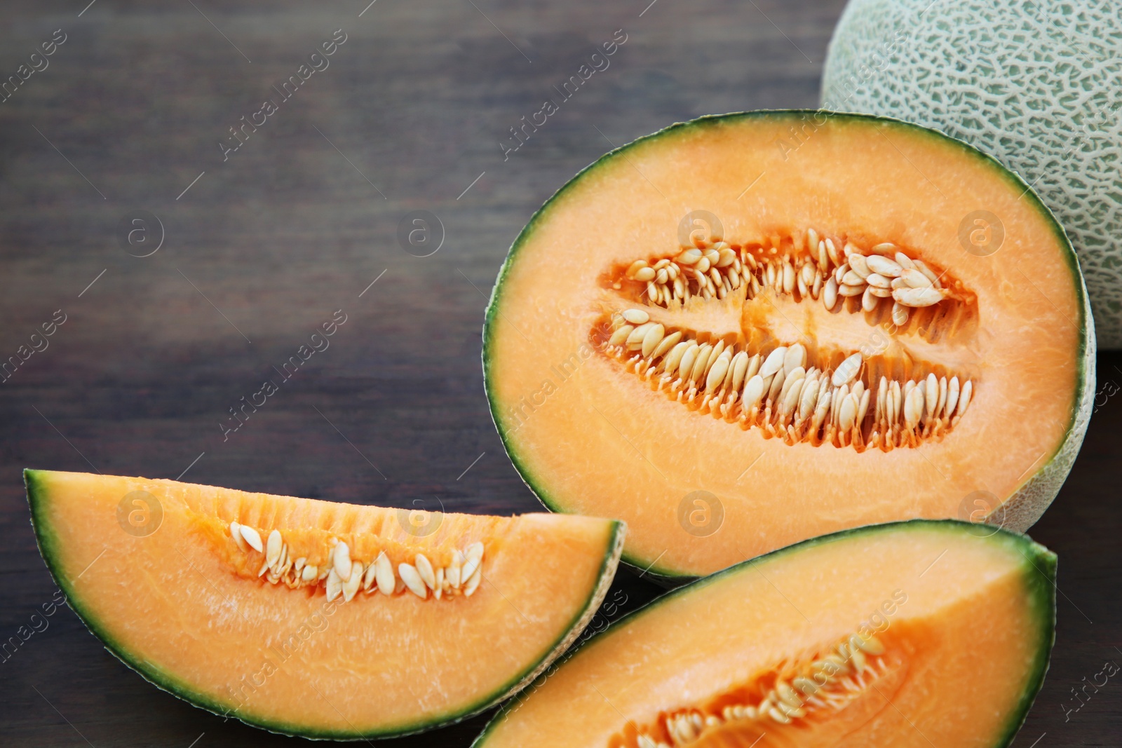 Photo of Tasty orange ripe melons on wooden table