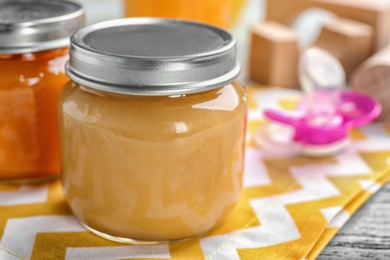 Jar with healthy baby food on table