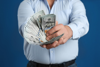 Photo of Senior man with cash money on blue background, closeup