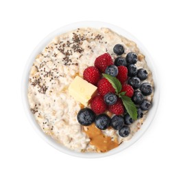 Photo of Tasty boiled oatmeal with berries, chia seeds and peanut butter in bowl isolated on white, top view