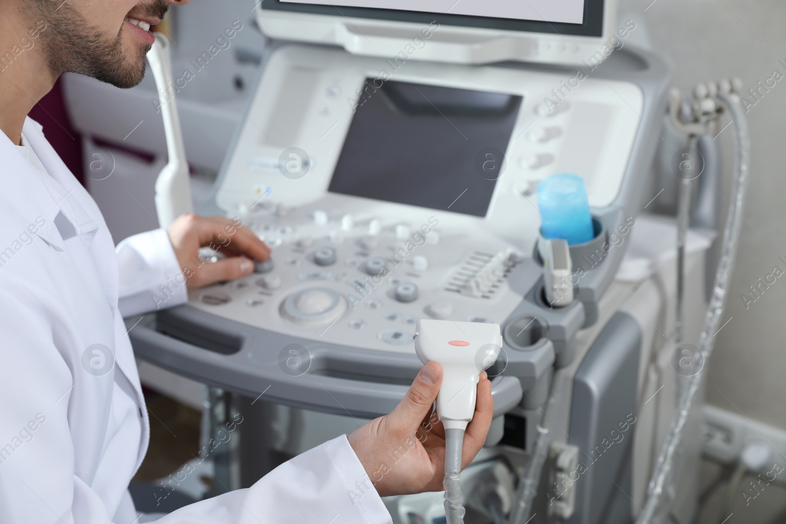 Photo of Sonographer using modern ultrasound machine in clinic, closeup