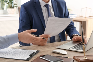 Photo of Lawyer working with client at table in office, focus on hands