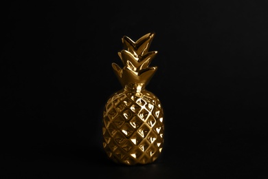 Photo of Gold metal decorative pineapple on black background