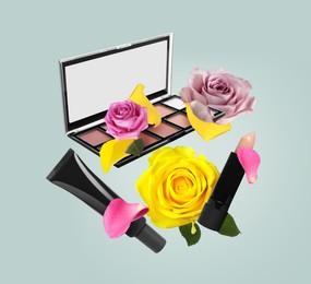 Image of Different makeup products and beautiful roses in air on light greyish blue background