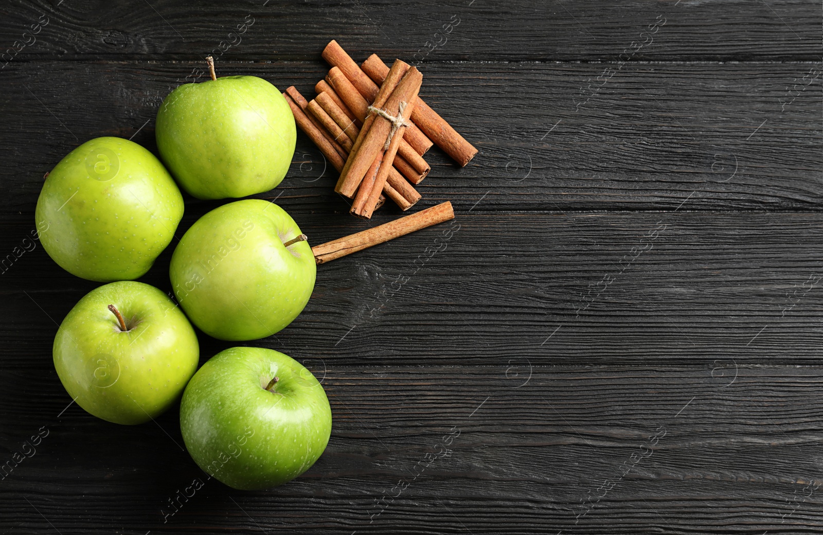 Photo of Fresh apples and cinnamon sticks on wooden table