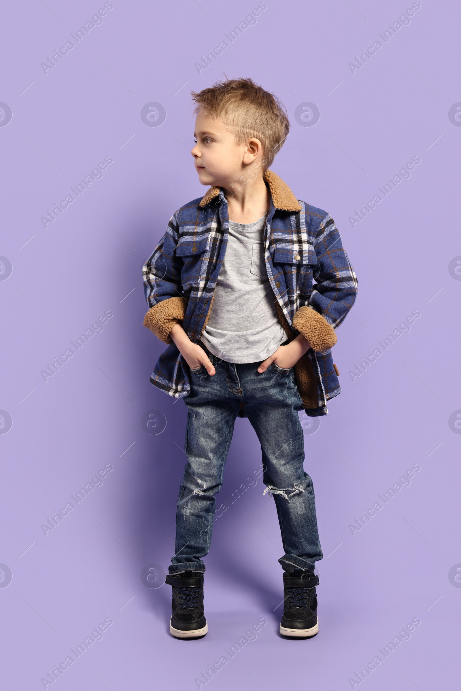 Photo of Fashion concept. Stylish boy posing on violet background