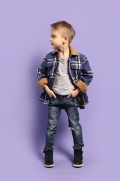 Photo of Fashion concept. Stylish boy posing on violet background