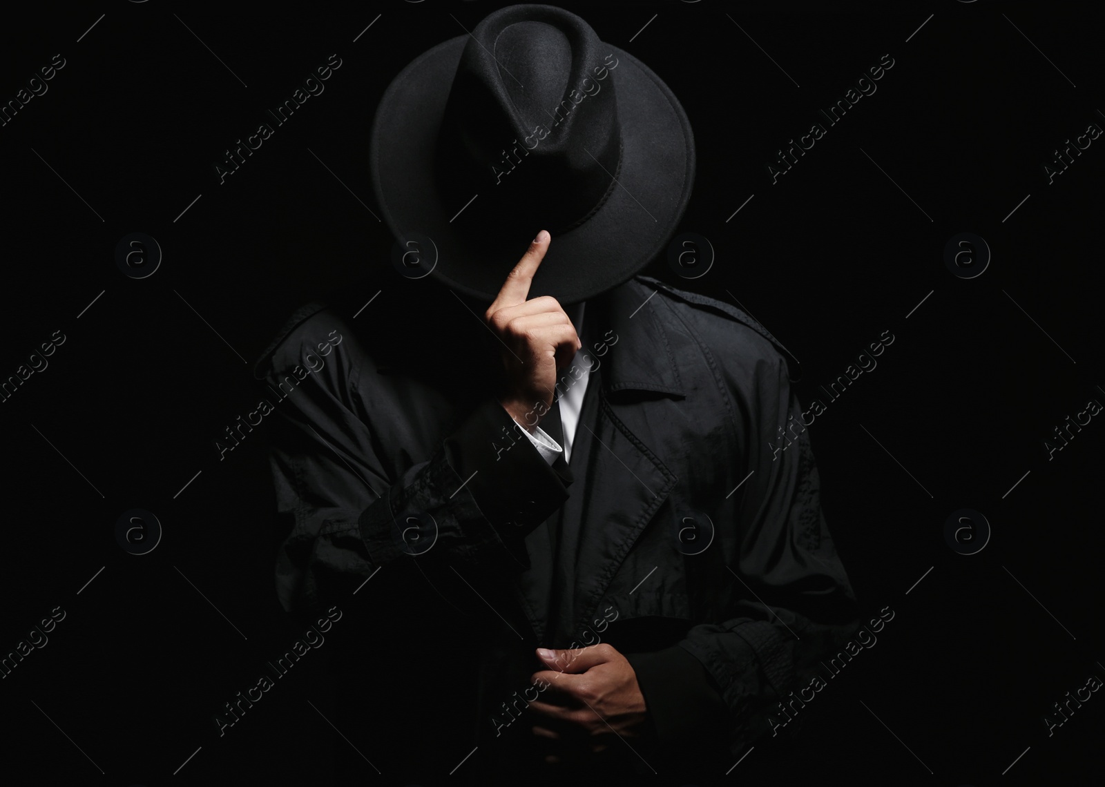 Photo of Old fashioned detective in hat on dark background