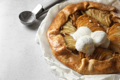Delicious apple galette served with ice cream on light grey textured table, closeup. Space for text
