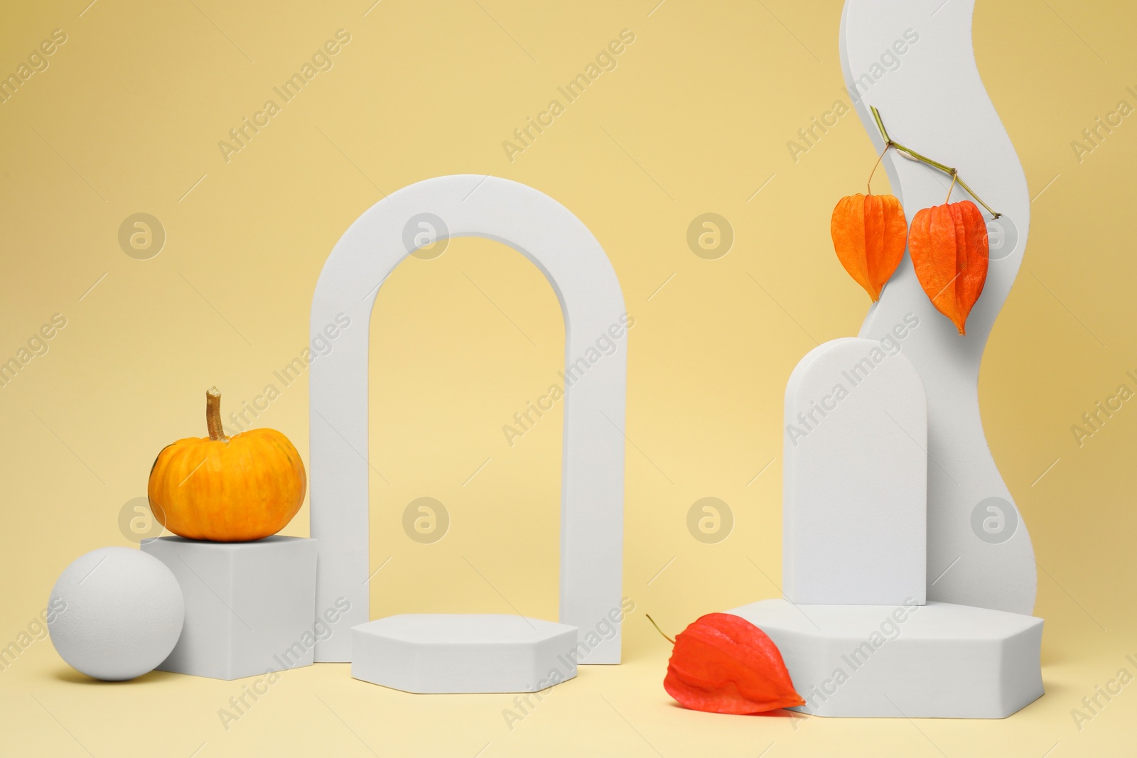 Photo of Autumn presentation for product. Geometric figures, pumpkin and physalis on beige background