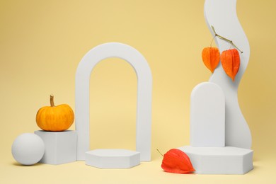 Autumn presentation for product. Geometric figures, pumpkin and physalis on beige background