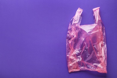 Photo of Clear disposable plastic bag on color background. Space for text