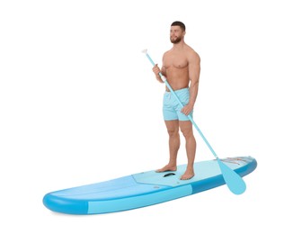 Handsome man with paddle on blue SUP board against white background