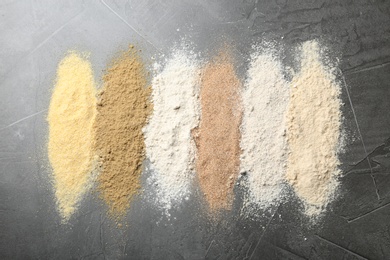 Photo of Stripes of different flour types on grey table, top view