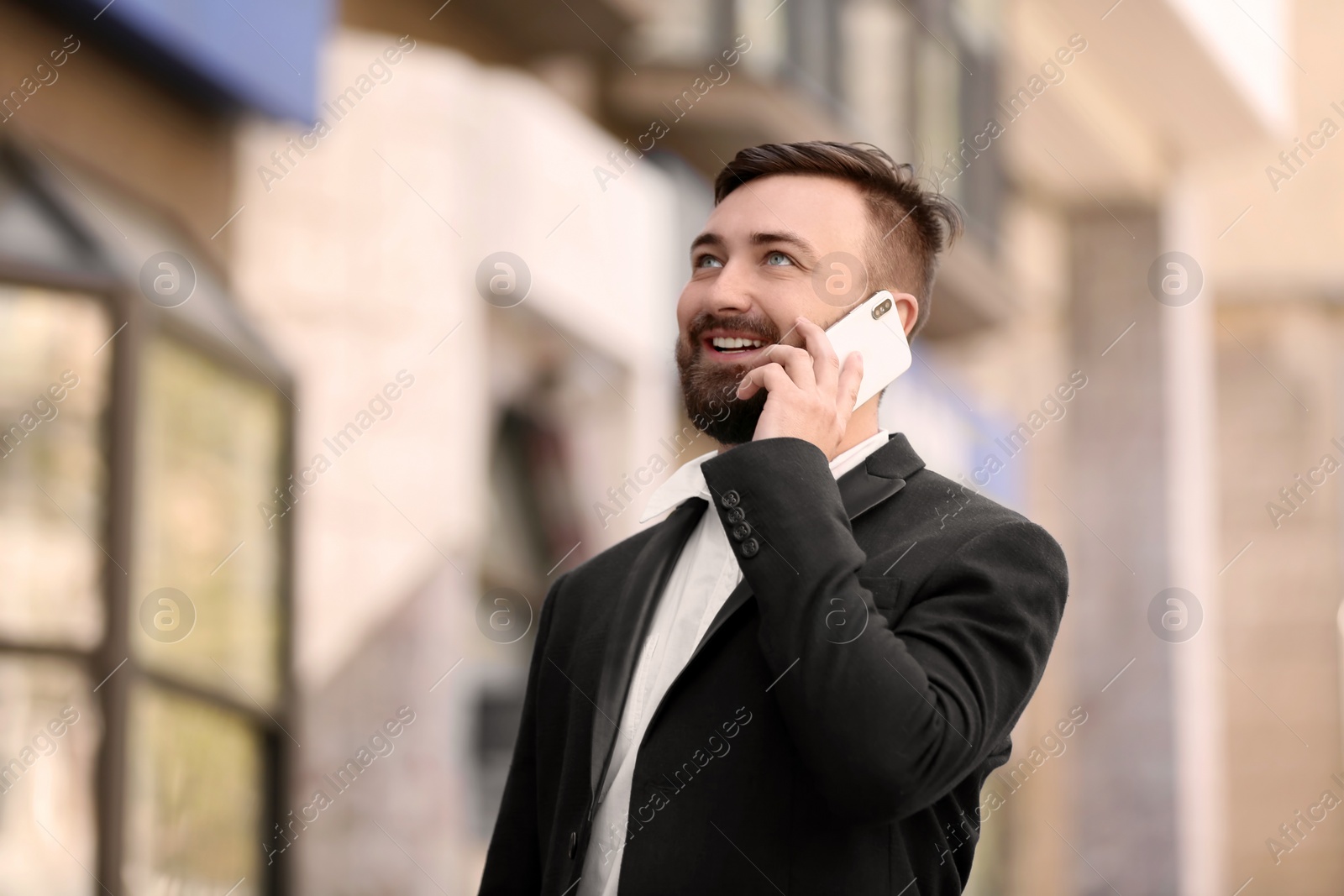 Photo of Portrait of young businessman talking on phone outdoors