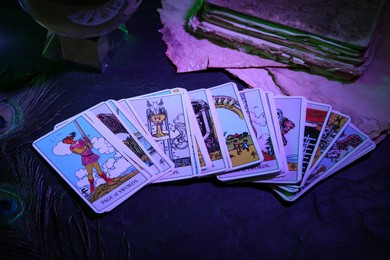 Photo of Page of Swords and other tarot cards on dark table, color toned